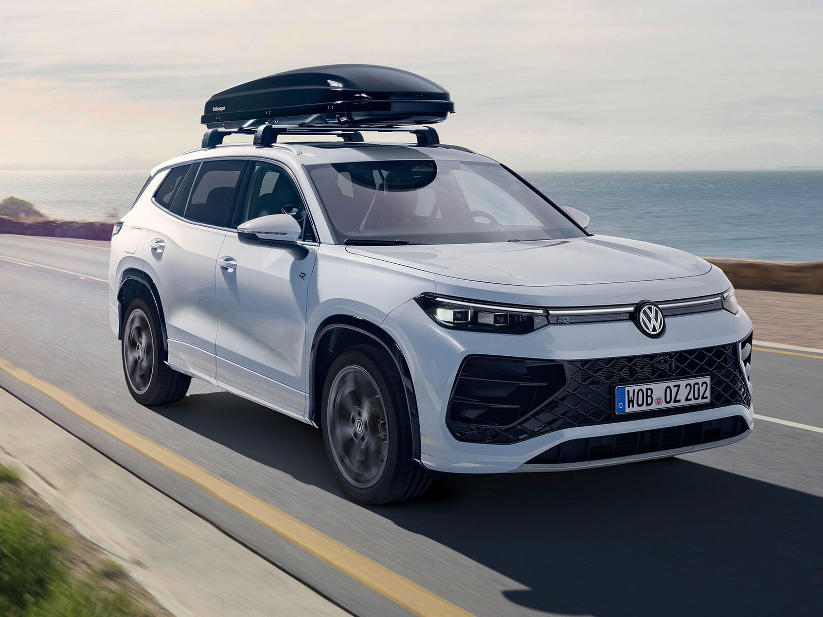 Bílý vůz Volkswagen se střešním boxem