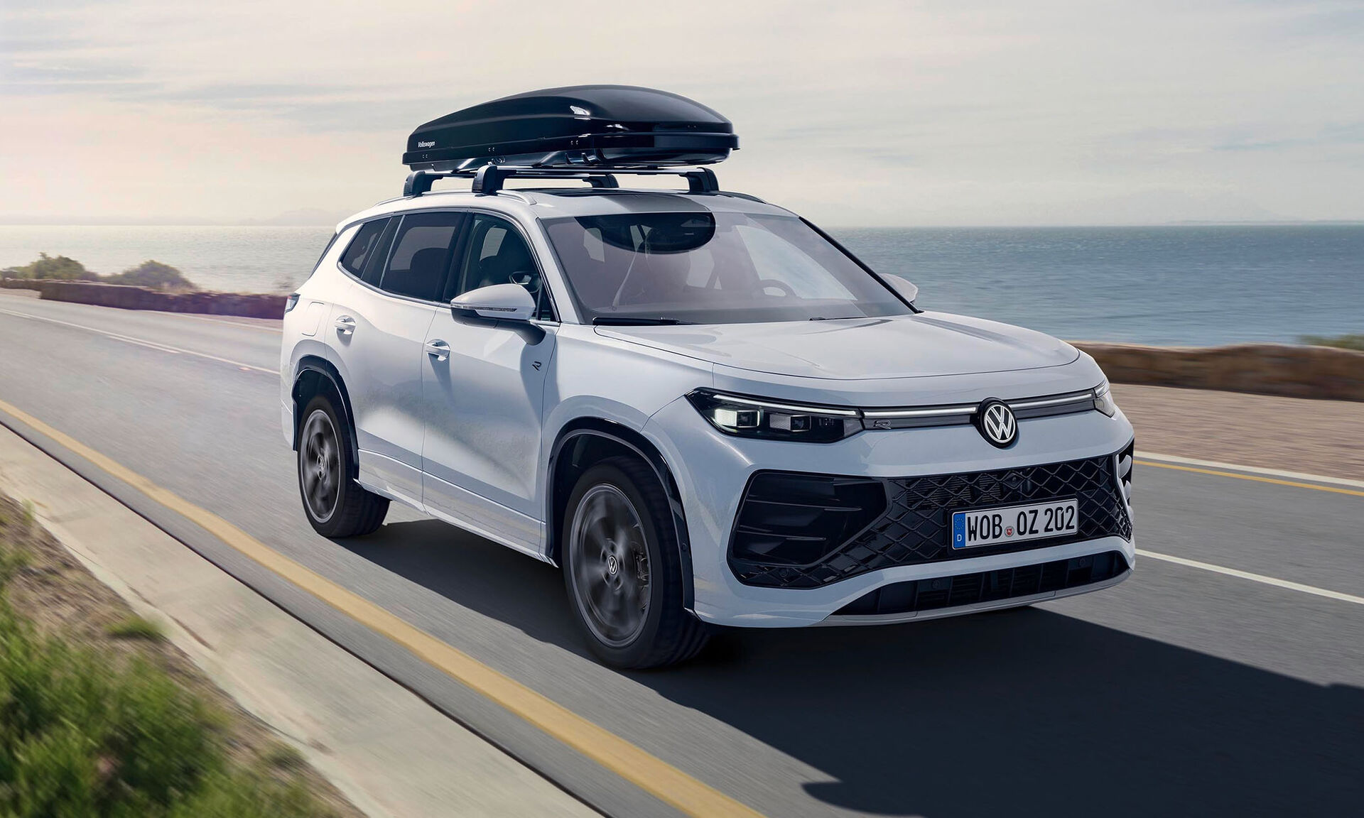 Bílý vůz Volkswagen se střešním boxem