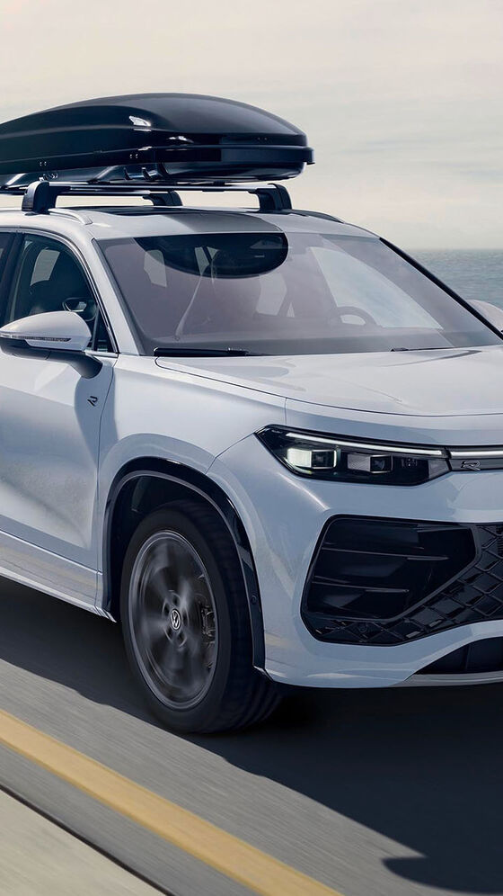 Bílý vůz Volkswagen se střešním boxem